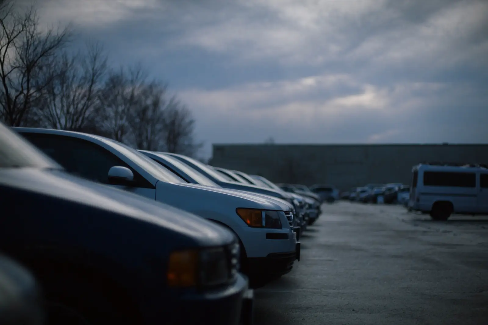Rows of vehicles parked in a holding lot on an overcast Michigan morning